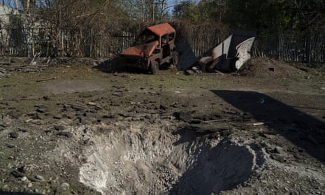 A destroyed car is seen next to a crater created by an explosion after a Russian attack in Zaporizhzhia, Ukraine.