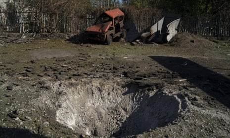 A destroyed car is seen next to a crater created by an explosion after a Russian attack in Zaporizhzhia, Ukraine.