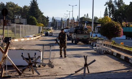 A Syrian fighter guards the entrance of the Khmeimim airbase