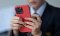 A 12-year-old schoolboy looks at an iPhone screen