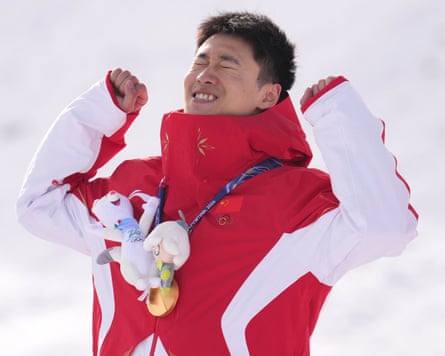 Wang Xindi fist pumps during the medal ceremony after the freestyle skiing men’s aerials at the 2026 Winter Olympics