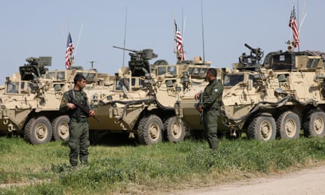 Kurdish YPG fighters guard  US military vehicles