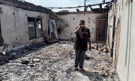 A man weeps among the ruins of a building razed by gunmen in Mamfe, south-west Cameroon, 6 November 2023.