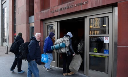 Mostly homeless people line up and wait to enter a Denver library to warm up and to use their resources.