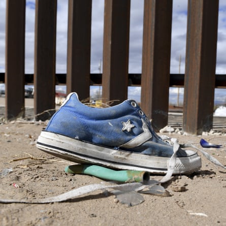 A shoe in front of the metal fence between Mexico and the United States in Puerto Anapra, Juarez