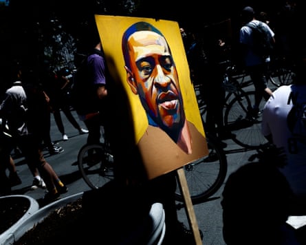 A person holds a portrait of George Floyd at the steps of Brooklyn Borough Hall.