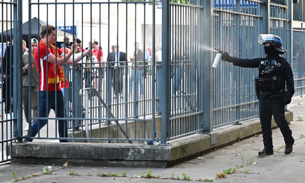 A policeman sprays teargas at Liverpool fans outside the Stade de France