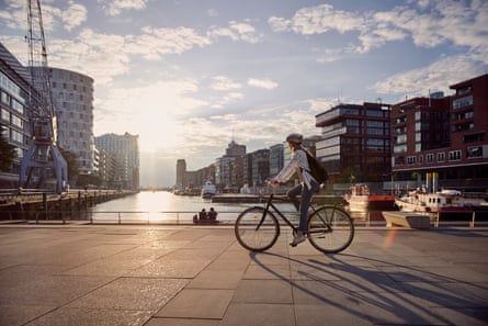 Young woman riding a bikeFull length of female riding bicycle in city against sky