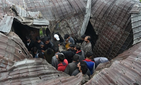 Local people inspect a damaged house following a gun battle between the Kashmiri militant Zakir Musa and the Indian military.