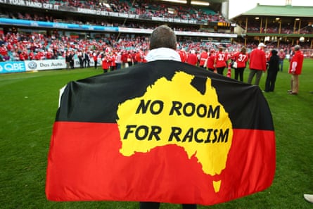 Fans display flags in support of Adam Goodes during the round 18 AFL match between the Sydney Swans and the Adelaide Crows at Sydney Cricket Ground in March.