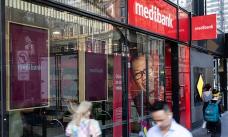People walk past a Medibank store in a busy urban setting