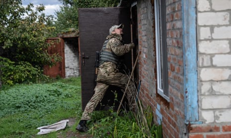 A Ukrainian soldier checks for anti-personnel mines and booby traps in a building previously used as a residence by Russian forces in Vyshneve.