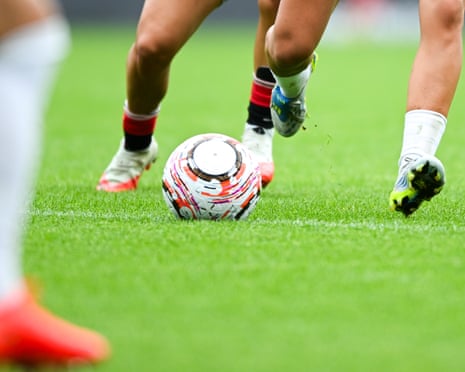 A view of female footballers boots and a ball during a game
