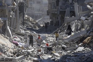 People in a destroyed, rubble-strewn street