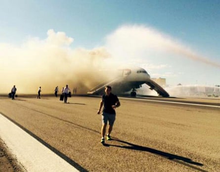 Passengers, including Jeremy Turnbull, front, flee from a British Airways plane alight at Las Vegas airport on 8 September 2015.