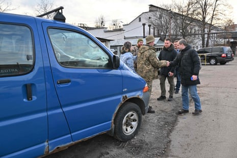 Volunteers hand over a repaired van to the Ukrainian armed forces.