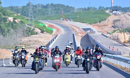 President Joko Widodo (2nd R) and Basuki Hadimuljono (3rd L), Minister of Public Works and Public Housing ride motorbikes as they inspect the progress of a new toll road linking Balikpapan and the new capital Nusantara