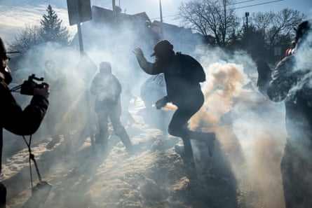 People run through a plume of teargas
