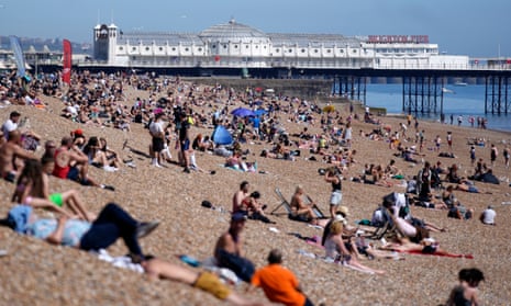 Beachgoers bask in the sun in Brighton.