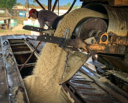 Man holds pole with machinery and product in foreground