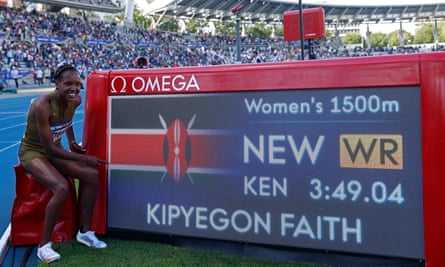 Faith Kipyegon poses with the clock after setting a new 1500m world record in Paris