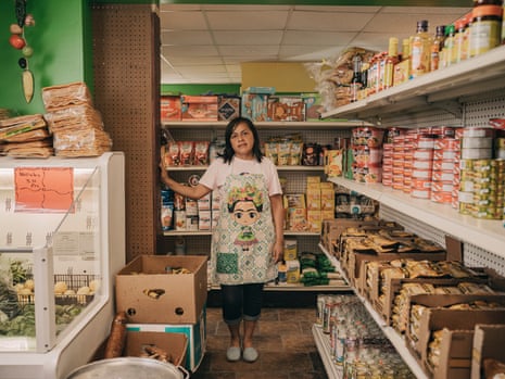 Maribel Lobato stands among the aisles of Veracruz Mexican market in Monroe, Wisconsin, surrounded by aisles of Mexican food products and a bin of fresh produce.