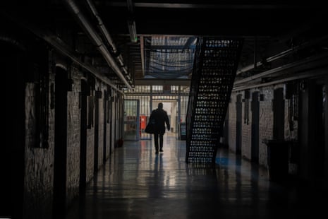 A figure walking through a dark prison wing