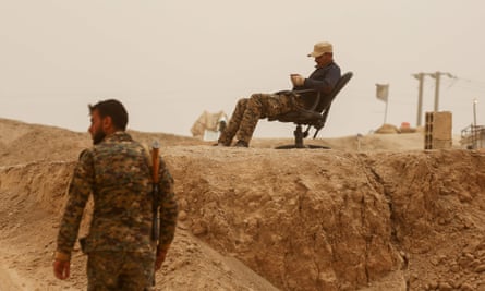 Fighter with the YPG – the Kurdish Peoples’ Protection Units - reading book near Raqqa frontline
