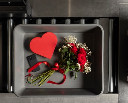 Flowers, a heart-shaped box of chocolates, a smartphone and housekeys in a security-scanner tray