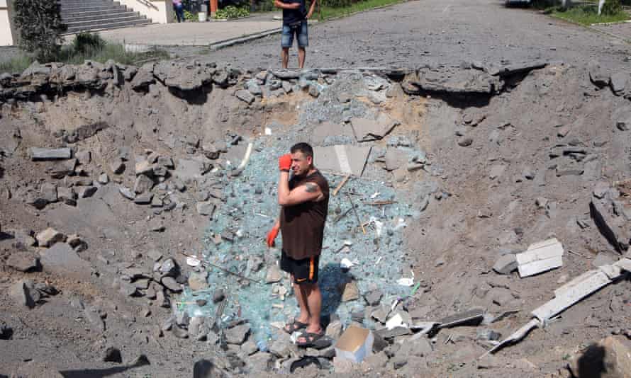 A man stands in the crater left by a Russian rocket near the Kharkiv State Zooveterinary Academy in Mala Danylivka village, Kharkiv Region, northeastern Ukraine.