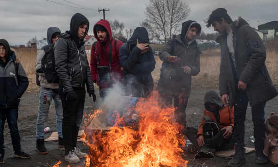 A group of people standing around a fire.