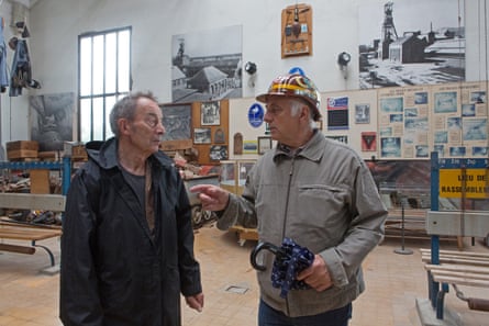 Two men stand inside a mining museum.