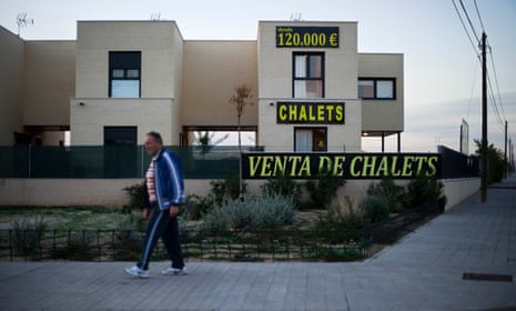 A man passes by a chalet for sale in Sesena, Spain.