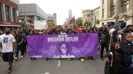 Protesters march through Louisville, Kentucky, after a grand jury decided not to bring homicide charges against police officers involved in the fatal shooting of Breonna Taylor