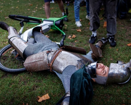 A participant falls off his bike during a Lime bike jousting in a park.