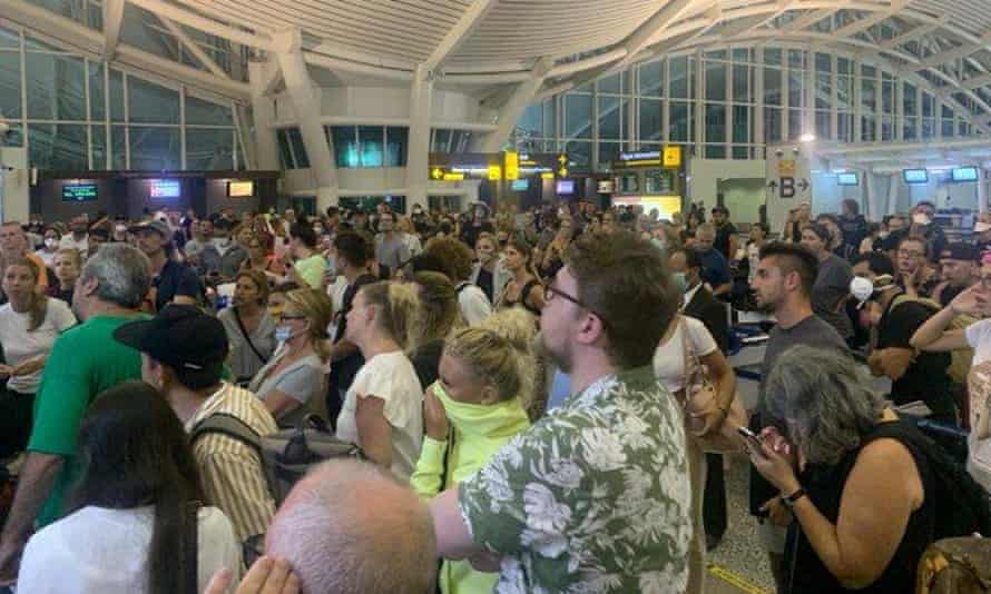 Travellers check for updates at Denpasar airport in Bali, as more than 100 British travellers have found themselves stranded due to the coronavirus travel restrictions.