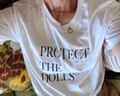 a plain white T-shirt bearing the slogan Protect the Dolls