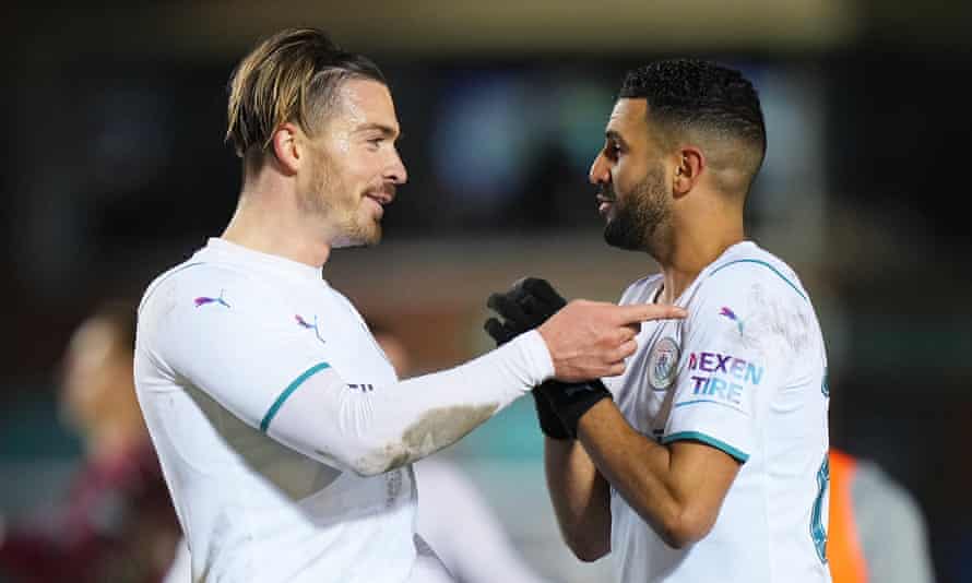 Jack Grealish celebrates with Riyad Mahrez after their goals took Manchester City past Peterborough.