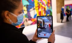 A visitor to the Serpentine North Gallery uses the Acute Art app to display augmented reality art by Kaws. 