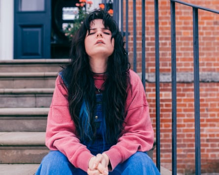 Gabrielle Creevy looking stressed, sitting on steps outside a house