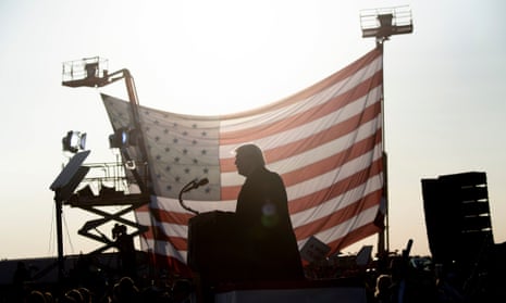 Donald Trump is seen in silhouette against a US flag as he speaks at a rally on September 18, 2020.