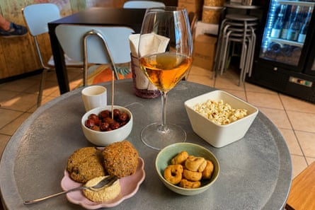 Orange wine with meat and aubergine polpette, dressed olives and popcorn on a table at Tor-Tor.