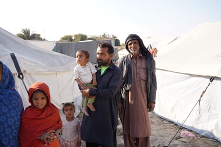 Manzoor Ali, right, with his neighbour at the camp, Badal Chandio, who is holding his son.