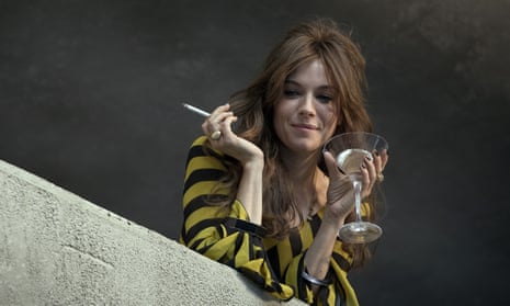 Sienna Miller with a martini in one hand and a cigarette in the other in the film High-Rise
