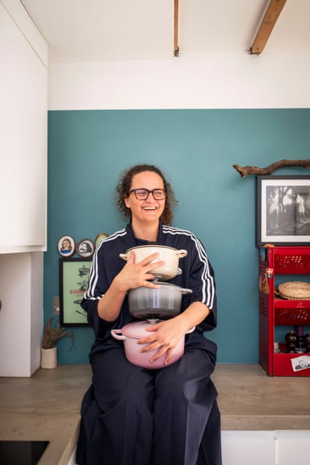 Dale Berning Sawa holding three cast-iron pots.