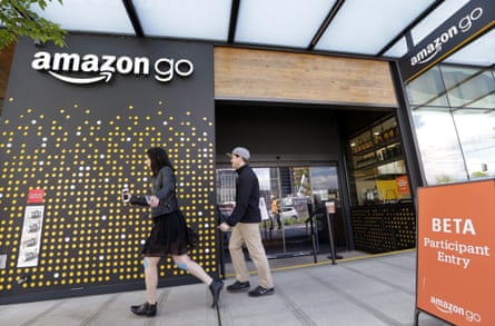 People walk past an Amazon Go store, currently open only to Amazon employees, in Seattle. Amazon Go shops are convenience stores that don’t use cashiers or checkout lines, but use a tracking system that of sensors, algorithms, and cameras to determine what a customer has bought.