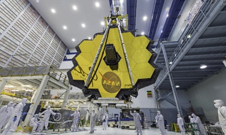 Nasa technicians lift the mirror of the James Webb space telescope into place using a crane