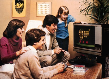 Atari 2600 Video Computer System, early video game, family with paddle playing “Space Invaders”, 1978