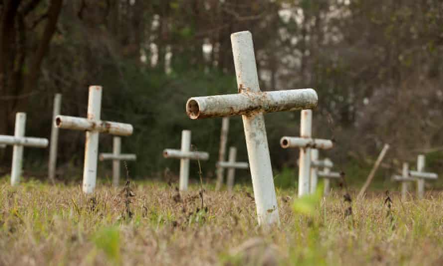 White metal crosses mark graves at the cemetery.