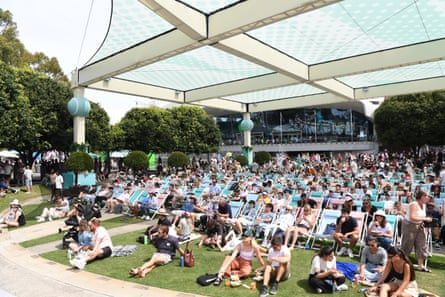 Spectators sit on chairs on the lawn at Melbourne Park